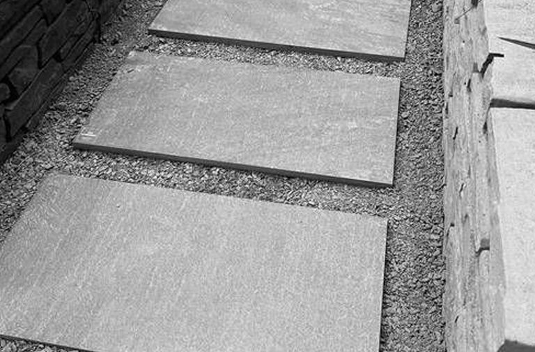 Pasos rectangulares de piedra filita gris, utilizado en caminos de jardines.